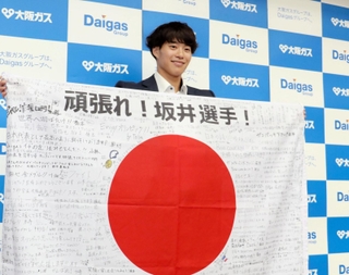 メッセージ入り日の丸とともに笑顔を見せる坂井隆一郎＝大阪市の大阪ガス本社