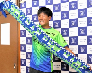 Ｊ１湘南入りが内定し、ユニホームに身を包み笑顔を見せる神戸弘陵高の石橋瀬凪＝神戸市北区、同高