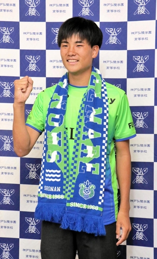 Ｊ１湘南入りが内定し、ユニホームに身を包み笑顔を見せる神戸弘陵高の石橋瀬凪＝神戸市北区、同高