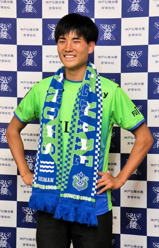 Ｊ１湘南入りが内定し、ユニホームに身を包み笑顔を見せる神戸弘陵高の石橋瀬凪＝神戸市北区、同高