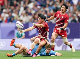 ウルグアイ戦でタックルされる野口（手前）＝パリ郊外（ゲッティ＝共同）