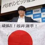 メッセージ入り日の丸とともに笑顔を見せる坂井隆一郎＝大阪市の大阪ガス本社