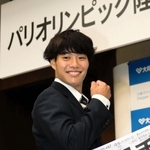 メッセージ入り日の丸とともに拳を握る坂井隆一郎＝大阪市の大阪ガス本社