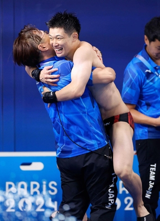 男子高飛び込み決勝の演技を終え馬淵崇英コーチ（左）と抱き合う玉井陸斗＝パリ郊外（共同）
