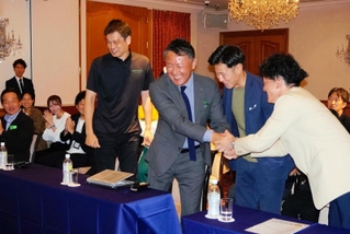 Ｂプレミア入りが発表され、関係者と手を取り合って喜ぶ神戸ストークスの渋谷順社長（右から３人目）ら＝神戸市中央区波止場町７、ホテル　ラ・スイート神戸ハーバーランド