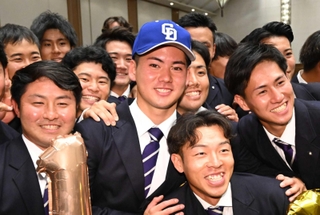 中日が１位で交渉権を獲得し、チームメートと笑顔で写真撮影に応じる関大の金丸夢斗投手＝２４日午後、大阪府吹田市の関大千里山キャンパス（撮影・大田将之）