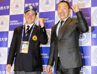 ドラフト１位指名を受けて中日の井上一樹監督（右）と笑顔でガッツポーズする関大の金丸夢斗投手＝２５日、大阪府吹田市の同校