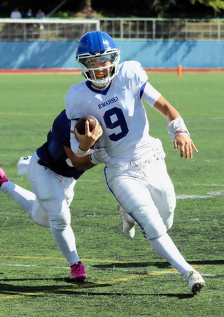 ランを仕掛ける関学のＱＢ長沢（９）。パスも絡めて攻撃のタクトを振るう＝神戸市灘区、王子スタジアム