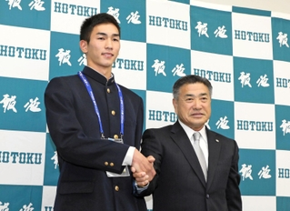 阪神の熊野輝光スカウト（右）と握手を交わす報徳高の今朝丸裕喜投手＝西宮市上大市の同校