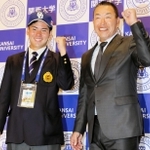 ドラフト１位指名を受けて中日の井上一樹監督（右）と笑顔でガッツポーズする関大の金丸夢斗投手＝２５日、大阪府吹田市の同校