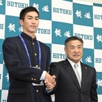 阪神の熊野輝光スカウト（右）と握手を交わす報徳高の今朝丸裕喜投手＝西宮市上大市の同校