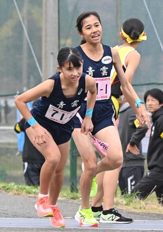 女子・青雲の１区片山紗良（右）からたすきを受ける２区富田結衣（撮影・大田将之）