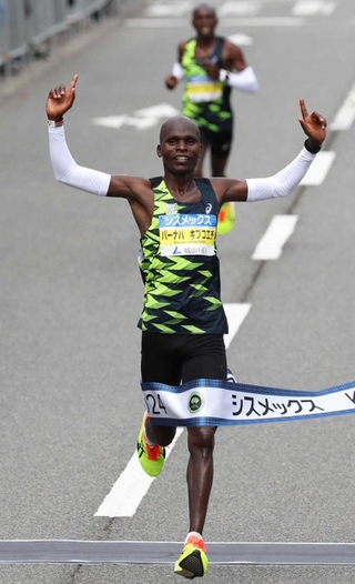 男子優勝のゴールテープを切るバーナバ・キプコエチ（撮影・辰巳直之）