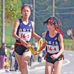 女子・西脇工の３区藤田このあ（左）からたすきを受け取る４区橋本晴菜