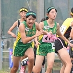 女子・飾磨西の１区堤彩花（右）からたすきを受けて駆け出す２区和田心奈（撮影・大田将之）