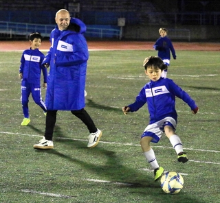 子どもたちとボールを追うイニエスタさん＝神戸市灘区、王子スタジアム