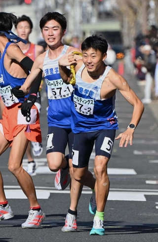 男子・須磨学園の１区藤岡孝太郎（左）が２区真田大輔にたすきを託す（撮影・大田将之）
