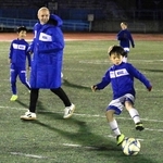 子どもたちとボールを追うイニエスタさん＝神戸市灘区、王子スタジアム