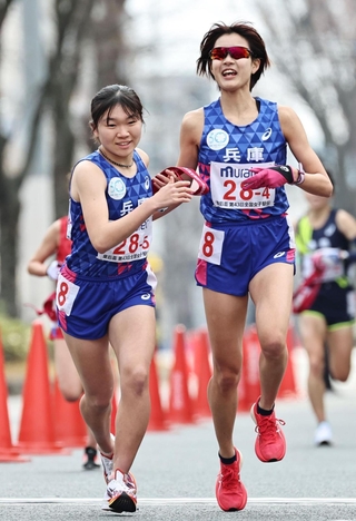 ４区の小林朝から５区の種知里にたすきが渡る＝１２日午後、京都市（撮影・長嶺麻子）