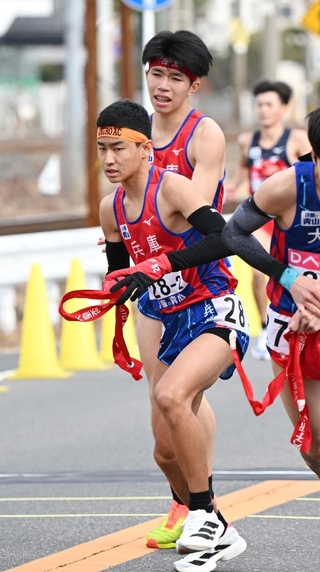 １区新妻遼己（奥）が２区岸本周真にたすきをつなぐ＝１９日午後、広島市西区（撮影・大田将之）