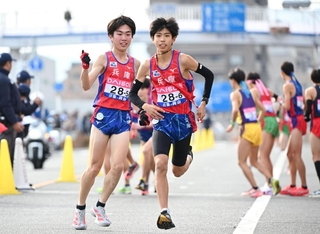 兵庫の５区藤岡孝太郎（左）が６区上山宙大にたすきをつなぐ＝１９日午後、広島市西区（撮影・大田将之）