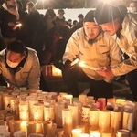 発生時刻を前に、東遊園地で灯籠に火をともしたラグビー神戸の選手ら＝神戸市中央区