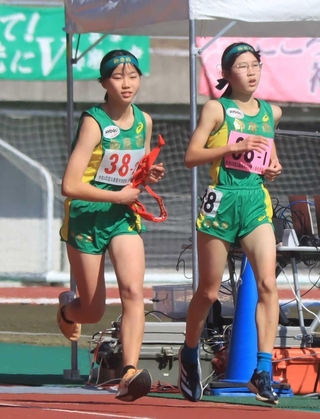 女子・飾磨西の１区堤彩花（右）からたすきを受けた２区田上奏