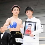穴口一輝さんの名前の入ったトランクスで勝利した大橋哲朗（左）と遺影を持って応援した小林豪己＝２０２４年１２月８日、エディオンアリーナ大阪第２競技場