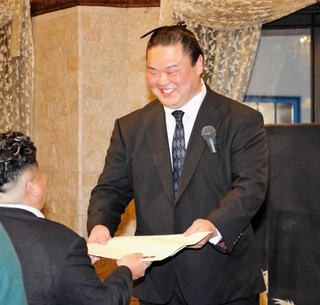 引退と年寄襲名報告会の抽選で景品を手渡す元関脇妙義龍の振分親方＝姫路市神屋町３、ラヴィーナ姫路