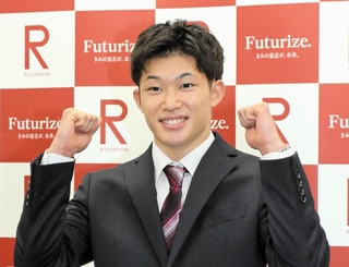 立命館大の入学式後の取材でポーズを決める玉井陸斗＝京都市左京区