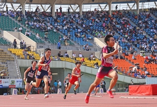 中学男子４００メートルリレーでスタンドの声援を受けて走る選手たち＝１９日午後、神戸市須磨区緑台、ユニバー記念競技場（撮影・笠原次郎）