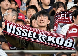タオルを広げ、神戸と岡山の試合をスタンドで観戦する兼本正光さん＝３日午後、神戸市兵庫区、ノエビアスタジアム神戸（撮影・斎藤雅志）