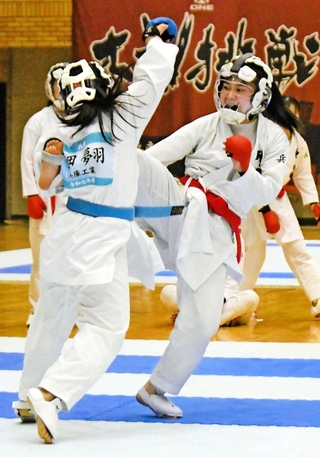 空手女子団体組手決勝　中段蹴りを放つ神港学園の穐野（右）＝神戸常盤アリーナ