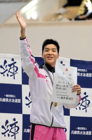 競泳男子１５００メートル自由形を大会新記録で制し、表彰台から手を振る須磨学園の上岡凌太
