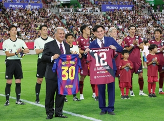 試合前にユニホームを交換するバルセロナのジョアン・ラポルタ会長（手前左）と神戸の三木谷浩史会長（同右）＝ノエビアスタジアム神戸（撮影・笠原次郎）