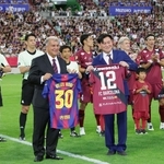 試合前にユニホームを交換するバルセロナのジョアン・ラポルタ会長（手前左）と神戸の三木谷浩史会長（同右）＝ノエビアスタジアム神戸（撮影・笠原次郎）