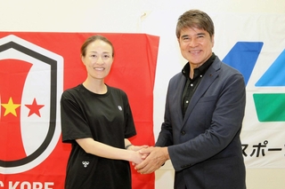 握手を交わす永島昭浩さん（右）とＩＮＡＣ神戸の宮本ともみ監督＝神戸市東灘区向洋町中７、神戸レディースフットボールセンター