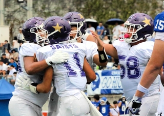 関学－啓明　第２クオーター、タッチダウンを決めた長友（１１）の元に駆け寄って喜ぶ啓明の選手たち