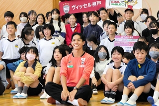 児童とふれ合い、記念写真に笑顔で納まる神戸の武藤（手前中央）＝神戸市兵庫区、会下山小学校