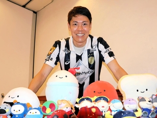 Ｊリーグのマスコットなど関わったグッズを前に笑みを浮かべる元Ｊ１神戸の伊野波雅彦さん＝ノエビアスタジアム神戸