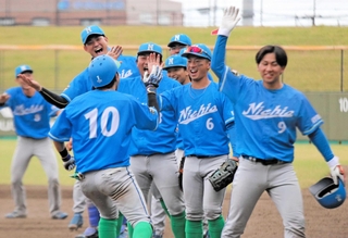 決勝で７回に２ランを放った中村主将（１０）を笑顔で出迎える日亜鋼業ナイン