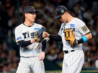 阪神-ソフトバンク　７回表、３者凡退に仕留め、佐藤とハイタッチする及川（左）＝２８日夜、西宮市の甲子園球場（撮影・丸山桃奈）