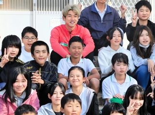 児童たちと笑顔で記念写真に納まる神戸の大迫（最後列中央）＝神戸市西区、東町小学校