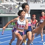 陸上成年少年男女混合１６００メートルリレー決勝　兵庫の第１走者の橋詰竜輝（右）からバトンを受け取る幸長愛美＝滋賀県平和堂ＨＡＴＯスタジアム（撮影・大田将之）