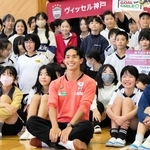 児童とふれ合い、記念写真に笑顔で納まる神戸の武藤（手前中央）＝神戸市兵庫区、会下山小学校