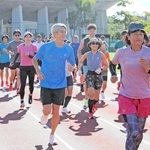 アシックスのランニングプログラム参加者と一緒に走る三津家貴也さん（中央）＝神戸総合運動公園