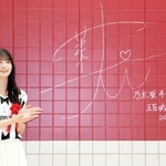 御崎公園駅でＪ１神戸カラーの深紅の壁にサインした乃木坂４６の五百城茉央さん＝神戸市兵庫区、同駅