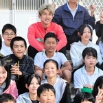 児童たちと笑顔で記念写真に納まる神戸の大迫（最後列中央）＝神戸市西区、東町小学校