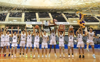 育英との接戦を制して２連覇を飾り、カップなどを掲げる報徳の選手たち＝神戸市須磨区のグリーンアリーナ神戸（撮影・吉田敦史）