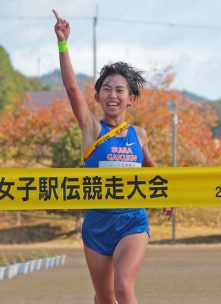 天に指を突き立て、笑顔でフィニッシュする女子・須磨学園のアンカー金子聖奈＝３日、丹波篠山市の篠山鳳鳴高校（撮影・秋山亮太）